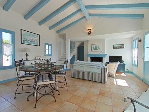 un salon avec une table, des chaises et un canapé dans l'établissement Charmante maison avec accès direct plage, jardin clos, 6 couchages, et ménage inclus - Noirmoutier - FR-1-224B-75, à Noirmoutier-en-l'lle