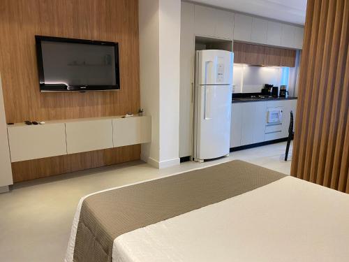 una cucina con frigorifero bianco e TV di LOFT Ed Carbono a Blumenau