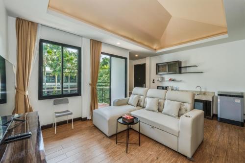 a living room with a couch and a table at Coco Retreat Phuket Resort and Spa - SHA Plus in Chalong
