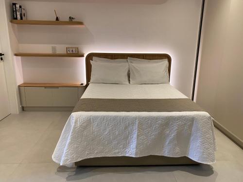 una camera da letto con un letto con un piumone bianco di LOFT Ed Carbono a Blumenau