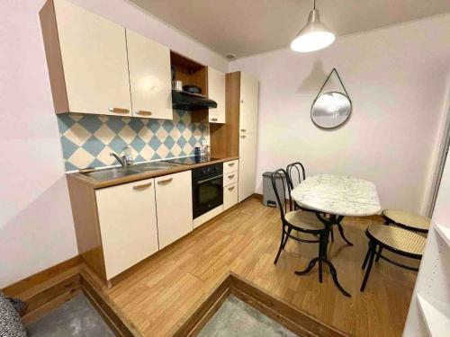 une cuisine avec une table et des chaises dans une pièce dans l'établissement Joli T2 plein cœur de Wazemmes - Lille, à Lille