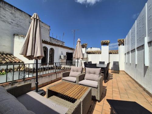 a patio with chairs and umbrellas on a building at BHost - Palace in Córdoba