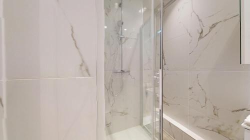 une salle de bain avec une douche avec une porte vitrée dans l'établissement Hallebardes Cathédrale, à Strasbourg