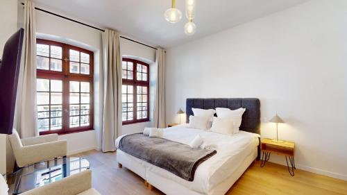 une chambre avec un lit et deux fenêtres dans l'établissement Hallebardes Cathédrale, à Strasbourg