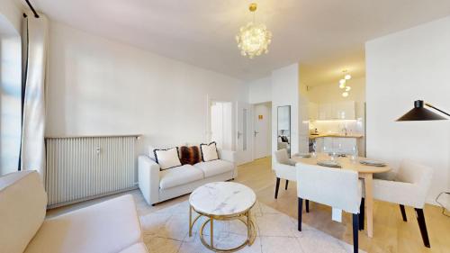 un salon avec un canapé blanc et une table dans l'établissement Hallebardes Cathédrale, à Strasbourg