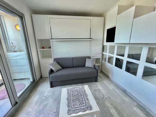 un salon avec un canapé et un lit dans l'établissement Studio climatisé avec grande terrasse et parking privé, proche plage et commerces - FR-1-716-60, à La Grande Motte