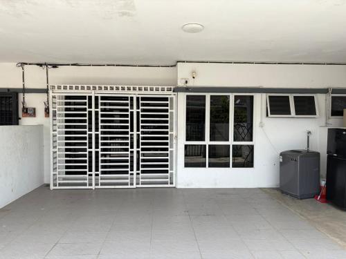 an empty garage with a gate and a door at Dhia Medina Homestay Jerantut in Jerantut