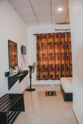 a room with a bed and a desk and a window at Aqua Hotel & Sea Food Restaurant Yala in Yala