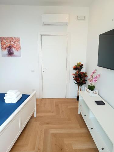 a white room with white furniture and a flat screen tv at La Piazzetta in Veroli