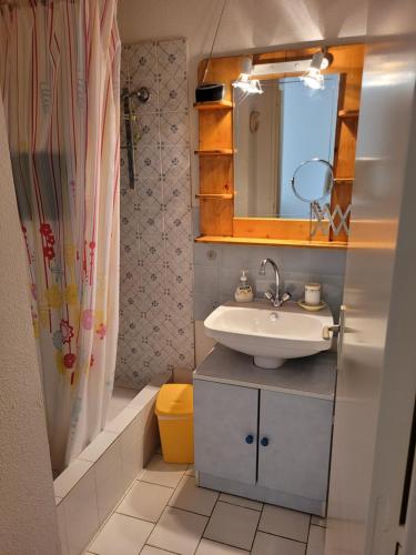 une salle de bain avec un lavabo et un miroir dans l'établissement Les jardins de la baie, à Cavalaire-sur-Mer