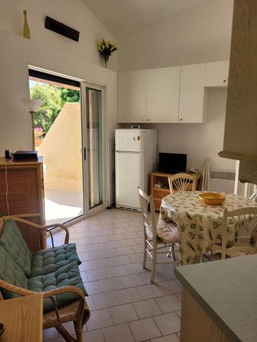 une cuisine et une salle à manger avec une table et des chaises dans l'établissement Les jardins de la baie, à Cavalaire-sur-Mer