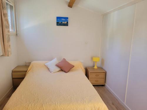 - une petite chambre avec un lit et une lampe dans l'établissement Les jardins de la baie, à Cavalaire-sur-Mer