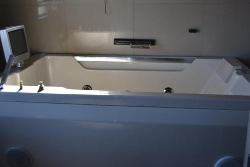 bañera con lavabo y espejo en abuntu guest house, en Vanderbijlpark