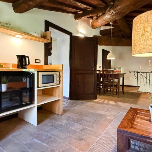 a kitchen with a microwave and a dining room at Bio Agriturismo Il Vigno in Caprese Michelangelo
