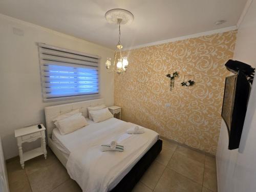 a bedroom with a bed with a cross on the wall at שקד באופק - וילה מקסימה עם 2 בריכות וג'קוזי מול החרמון in Metulla