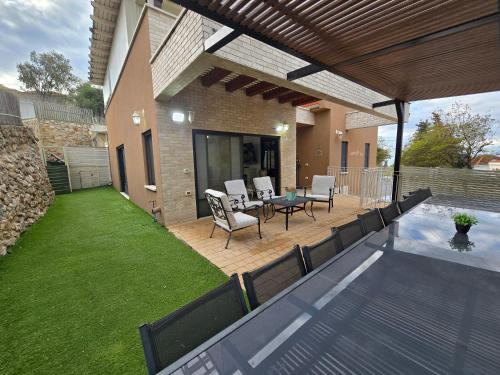 a patio with a table and chairs on a deck at שקד באופק - וילה מקסימה עם 2 בריכות וג'קוזי מול החרמון in Metulla