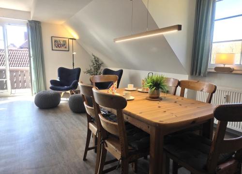 a dining room with a wooden table and chairs at Resi K6 in Prerow