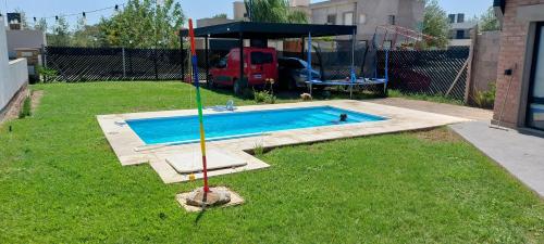 a swimming pool in a yard with a swing at Hermosa Casa Con pileta y quincho in Villa Nueva