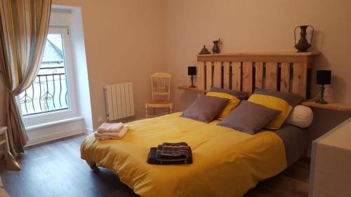 - une chambre avec un grand lit jaune et un plateau dans l'établissement La Ferme de Jean, à Saint-Vran