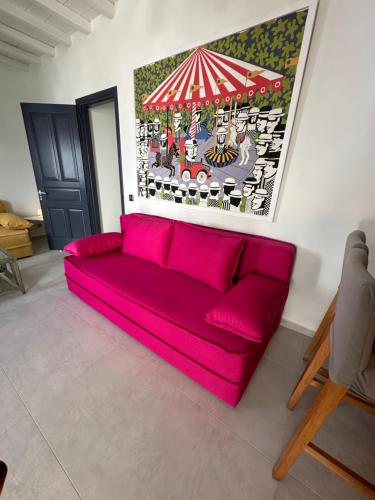 a red couch in a living room with a painting at Memories in Ornos
