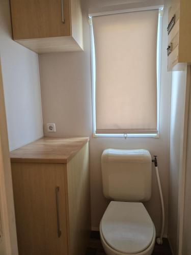 a small bathroom with a toilet and a window at camping Pradon in Arnuero
