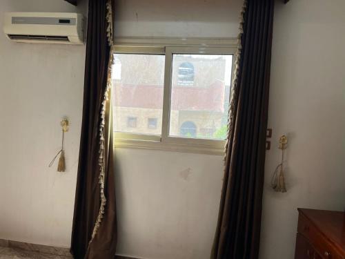 a window with a curtain in a room at Valley Of The Kings House in Luxor