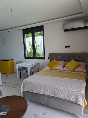 a bedroom with a large bed and a table at Apartmani Sunce Anja in Dobra Voda