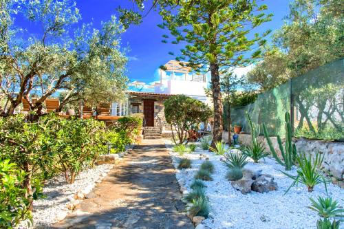 a garden with plants and a house at Cretan Lodge Heated Pool in Agios Nikolaos