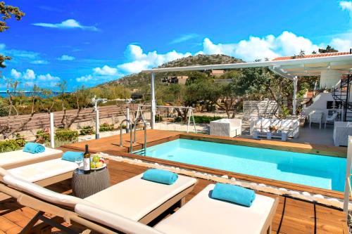 a swimming pool on a deck with lounge chairs next to it at Cretan Lodge Heated Pool in Agios Nikolaos