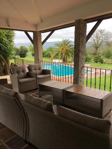 a patio with tables and chairs and a pool at The Hideaway at Quinta de Moçamedes - Suites & Apartments in Vouzela