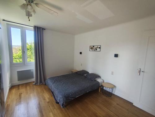 une chambre avec un lit et une grande fenêtre dans l'établissement Chez Nadette, à Saint-Vincent-de-Cosse