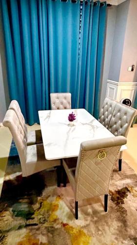 a dining room table and chairs with a blue curtain at HomeStaytion@Semenyih in Lengging