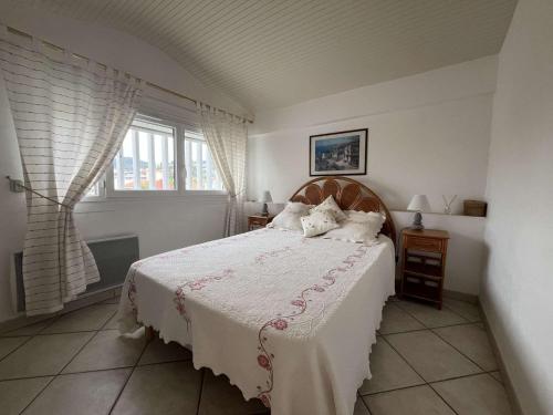 une chambre avec un lit avec des draps blancs et une fenêtre dans l'établissement Bel appartement climatisé 2 pièces au centre avec terrasse - FR-1-308-47, au Lavandou