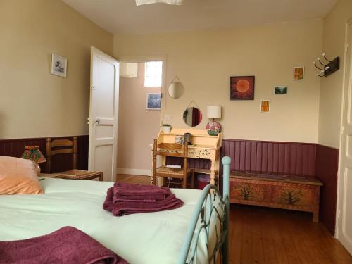 a bedroom with a bed and a table and a door at Chambre d'hôtes Les Glycines et petit déjeuner in Arnières-sur-Iton