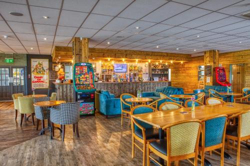 a restaurant with tables and chairs and a bar at Newlands Holidays in Bridport