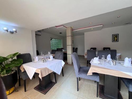 a dining room with two tables and chairs at Blackwood Hotels in Ikeja