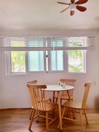 a dining room table with two chairs and a ceiling fan at Stay Hyuga Suwon in Suwon