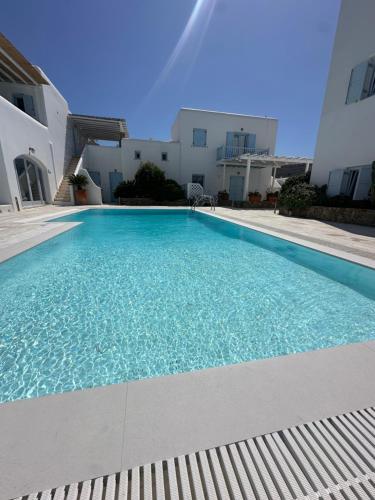 a swimming pool in front of a house at Mimoza Collection suites in Ornos