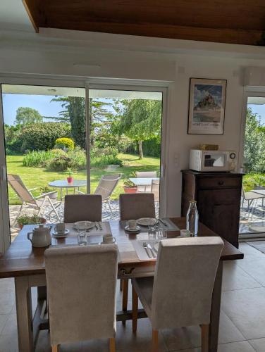 une salle à manger avec une table et des chaises en bois dans l'établissement A l ombre du Mont Saint Michel, à Huisnes-sur-Mer