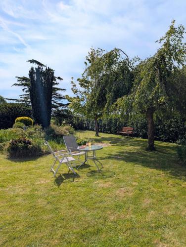 une table de pique-nique avec un ordinateur portable dessus dans l'herbe dans l'établissement A l ombre du Mont Saint Michel, à Huisnes-sur-Mer