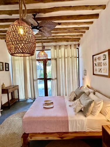 a bedroom with a large bed and a large window at Olamanga Beach Villa Adults Only in Jambiani