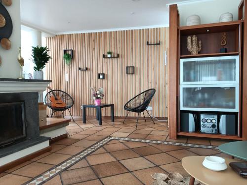 a living room with chairs and a fireplace at Surf & Guest Lorena´s House in Ribeira Grande