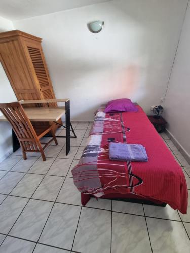 a bedroom with a bed and a chair and a piano at CHEZ LILIANE in Saint-Denis