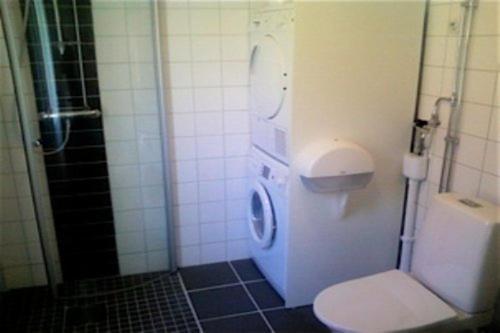 a small bathroom with a toilet and a shower at Äventyrsgårdens Vandrarhem, Kinnekulle in Källby