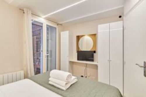 Cette chambre comprend un lit avec un miroir et une télévision. dans l'établissement Superb apartment Arc de Triomphe Trocadero, à Paris