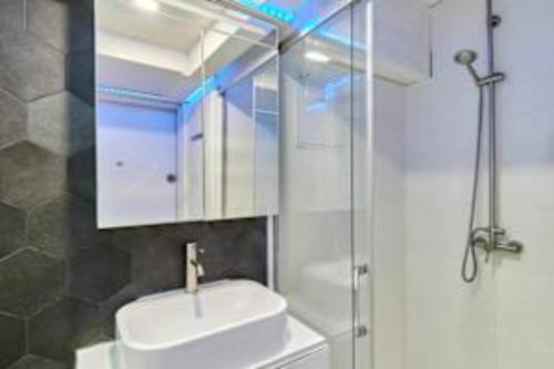 une salle de bain avec un lavabo et une douche en verre dans l'établissement Superb apartment Arc de Triomphe Trocadero, à Paris