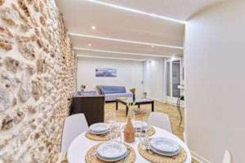 une salle à manger avec une table et un mur en pierre dans l'établissement Superb apartment Arc de Triomphe Trocadero, à Paris