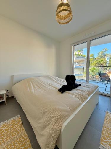 une chambre avec un lit sur lequel est allongé un chien dans l'établissement T3 near beach 15 min from Monaco, à Roquebrune-Cap-Martin