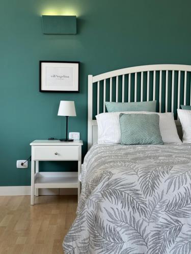 a bedroom with blue walls and a bed with a nightstand at Villa Angelina in Aquino