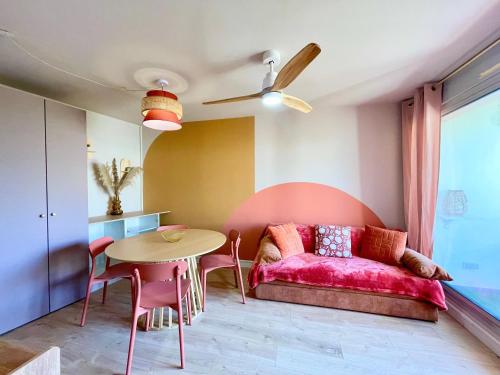 un salon avec un canapé rose et une table dans l'établissement PGH N40 Studio-cabine en première ligne & parking, à La Grande Motte
